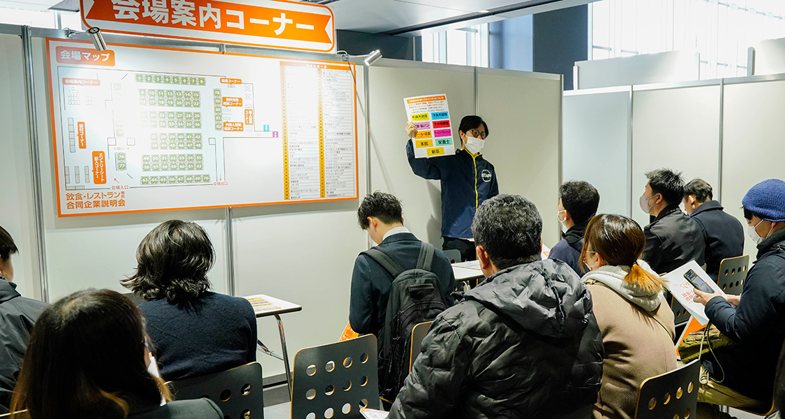 受付カウンターで説明を受ける女性