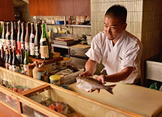 魚まみれ 眞吉／株式会社フィッシュウェル 求人 時季に合わせておすすめする旬の魚たちはキラリと鱗が輝きまだ生きている新鮮な状態でネタケースにズラリと並べています！