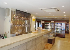 びあマ＋びあマBAR／株式会社 谷口 求人 店内に入ると広い空間と壁一面に広がる様々な種類のクラフトビール。ビール好きはワクワクすること間違いなし！