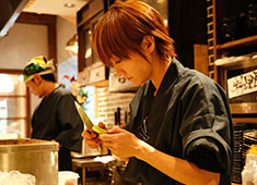 「酒場 髙しな 秋葉原店」 求人 女性スタッフもカウンターに立って料理しています！男女関係なく活躍できる環境ですよ！